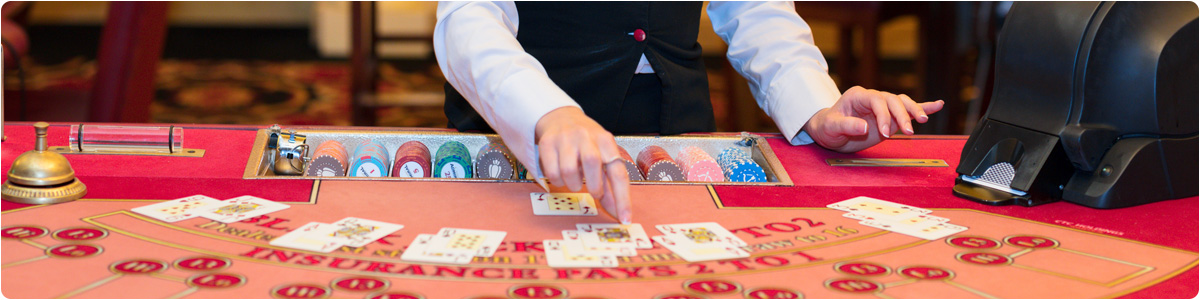 image of a Las Vegas casino dealer placing cards on a blackjack table