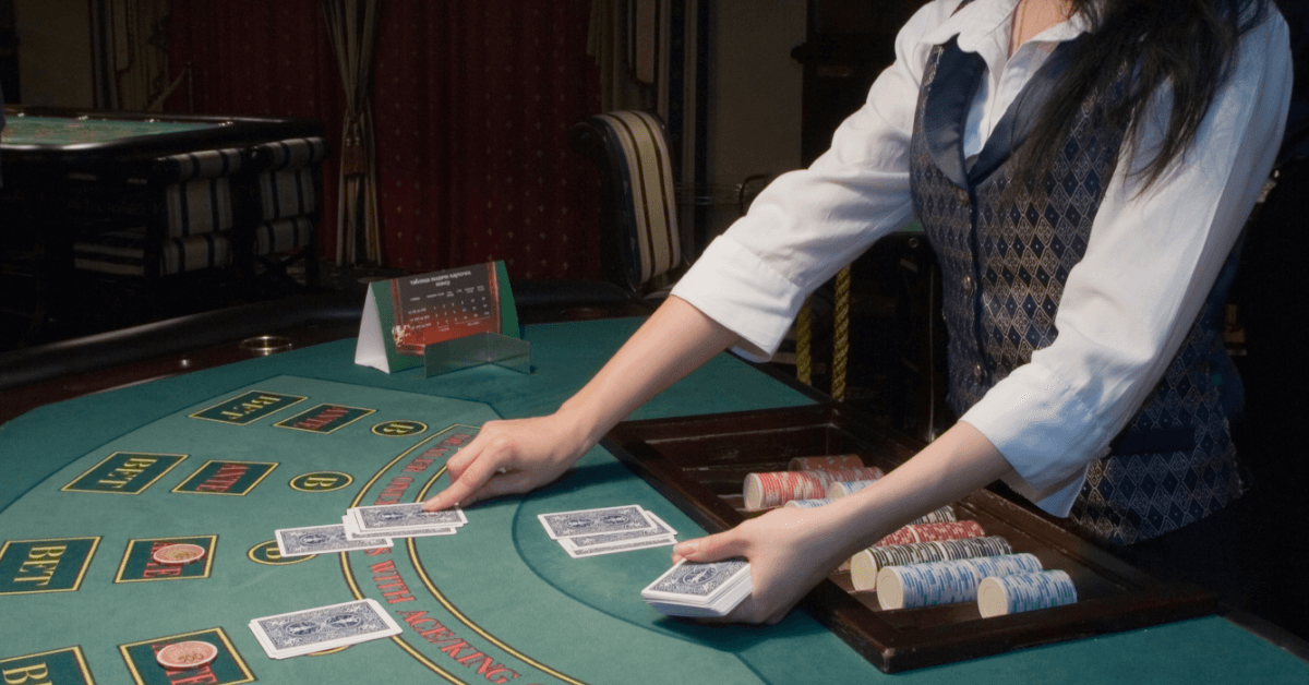Casino dealer distributing cards at table